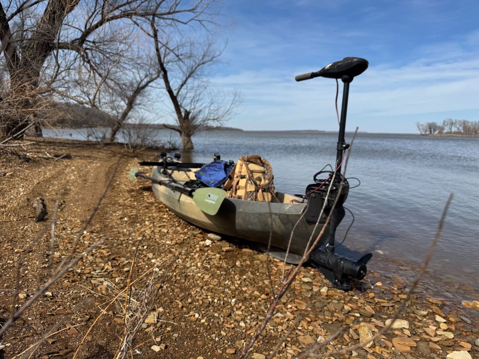 kayak-by-the-shore The kayak is positioned on the shore, ready for the hunt with its motor and gear