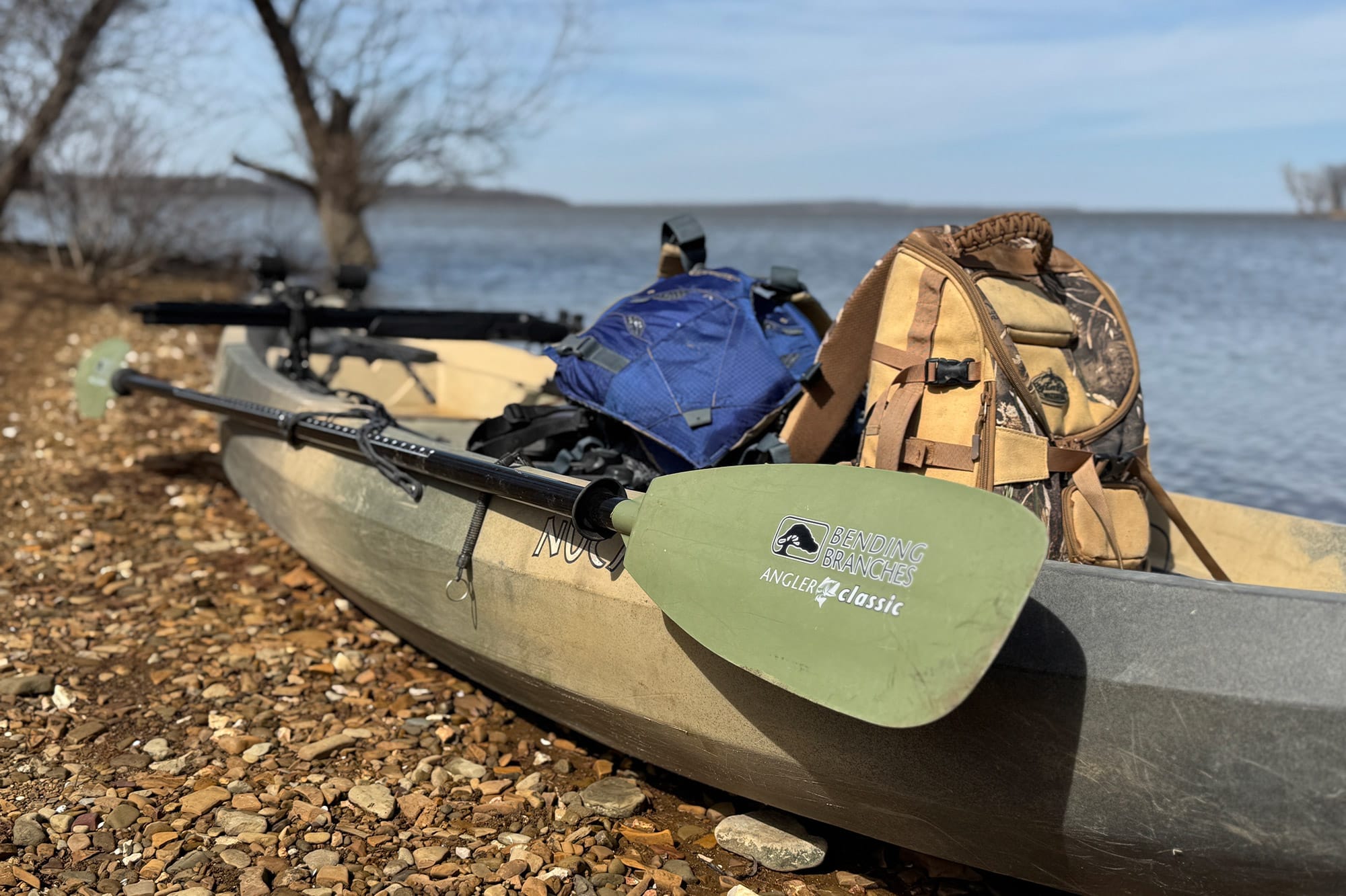 A Bending Branches paddle and hunting gear are stored on the kayak
